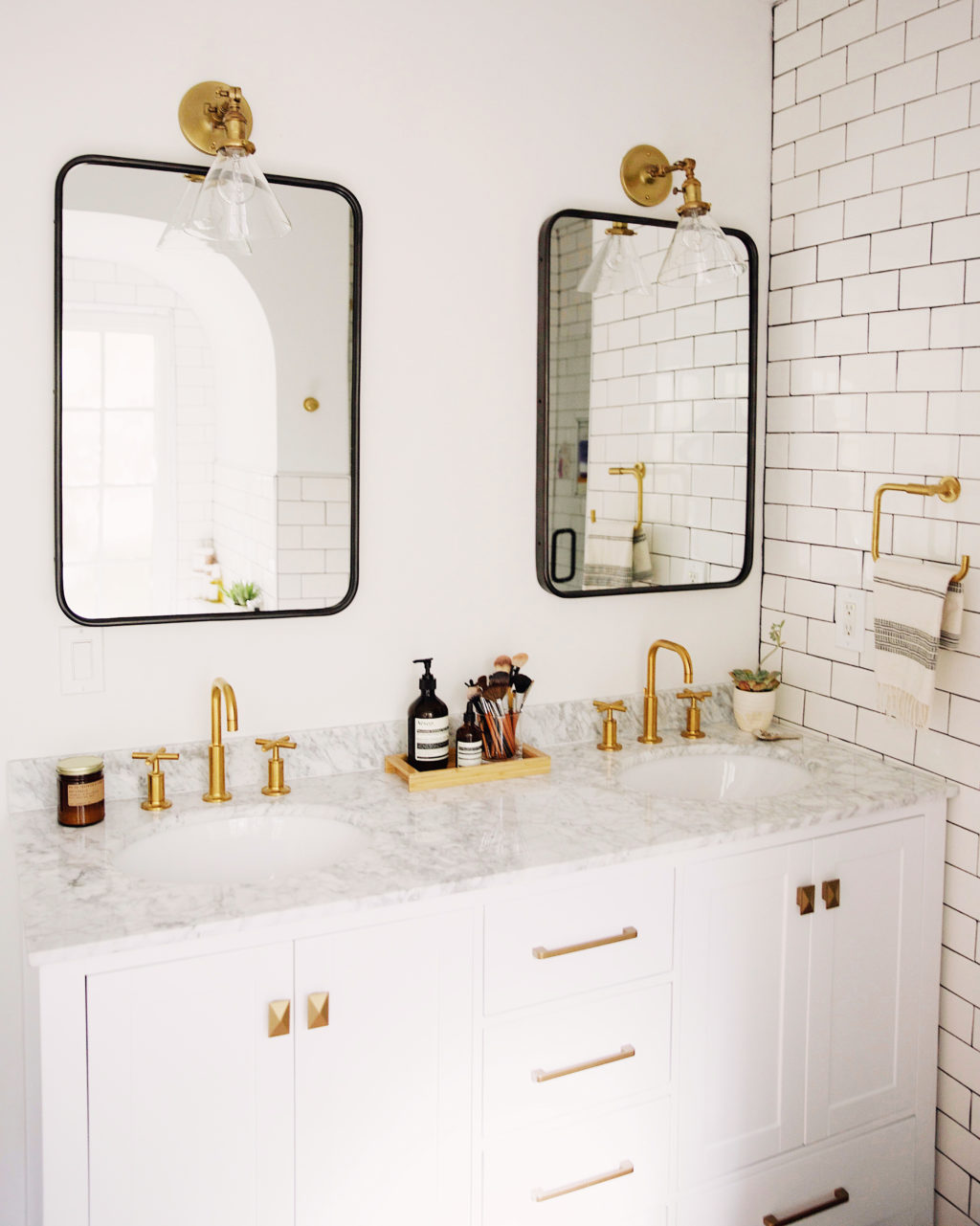 Minimal black and white subway tile bathroom with brass accents